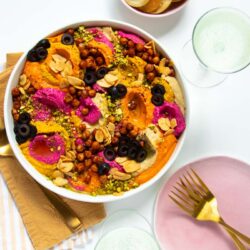 Dollops of hummus topped with a variety of toppings and served with sparkling wine and pita chips.