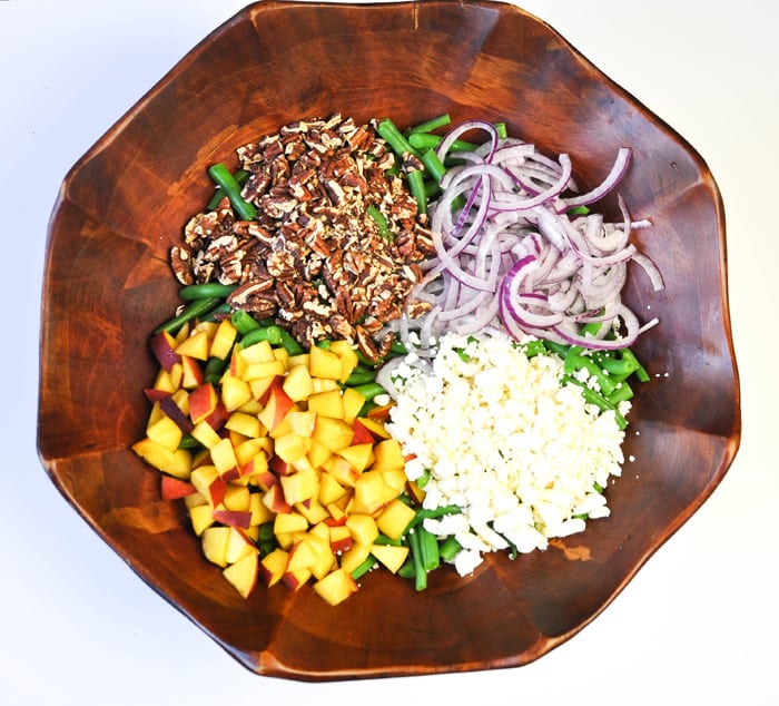 California Harvest Salad Ingredients Chopped in Bowl: Red Onion, Peaches, Green Beans, Pecans, and Crumbled Feta Cheese