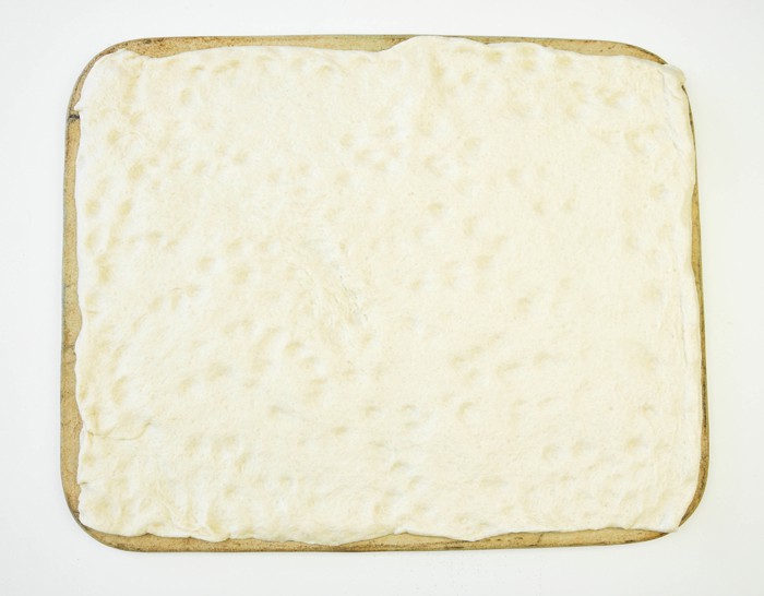 Dough placed on a pizza stone or cookie sheet