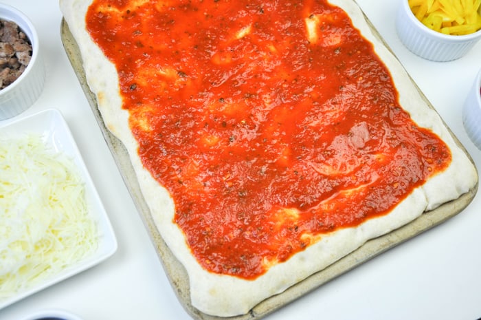 Pizza sauce placed onto the prebaked dough