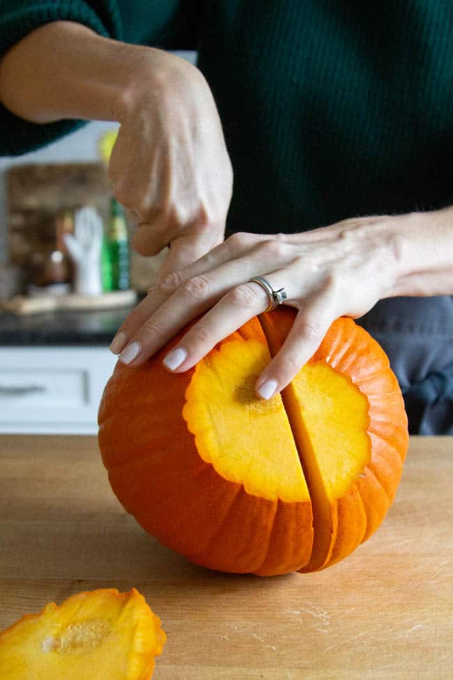 A pumpkin being cut in half.
