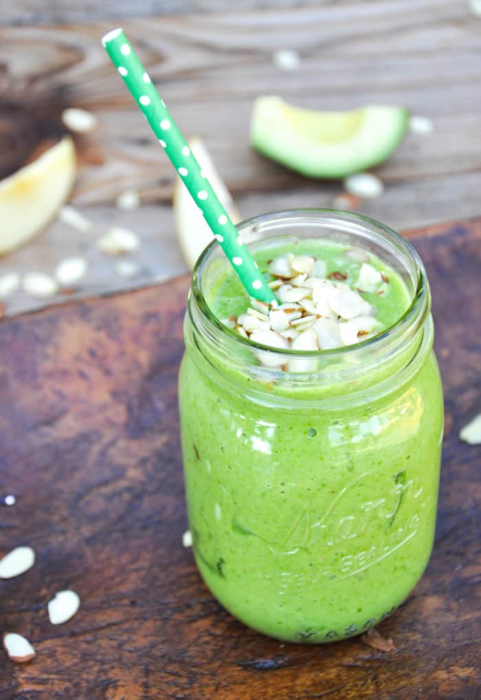 California Green smoothie in mason jar with straw and almond slices on top