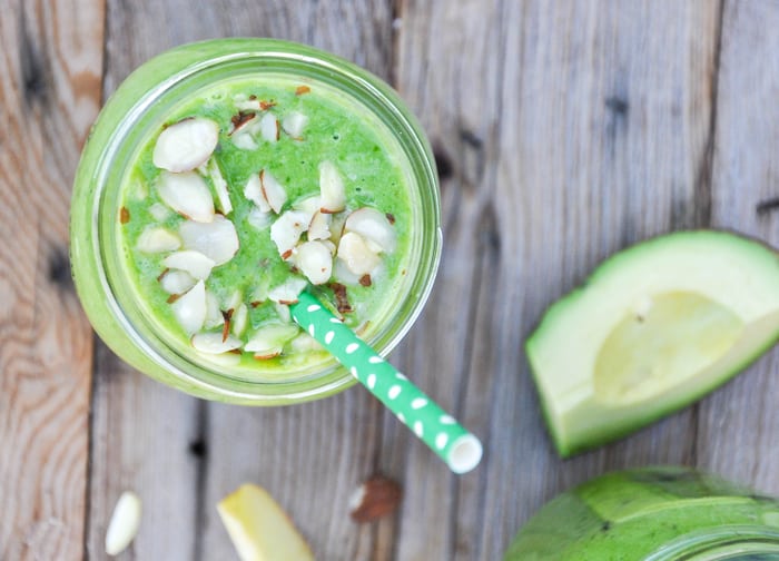 Birdseye view of green smoothie, topped with almonds