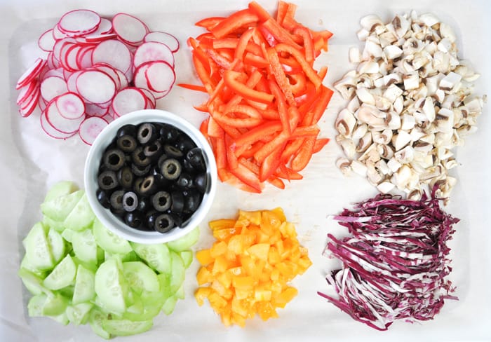 Mason Jar Salad ingredients: radish, red bell pepper, mushroom, black olives, cucumber, and radicchio. 