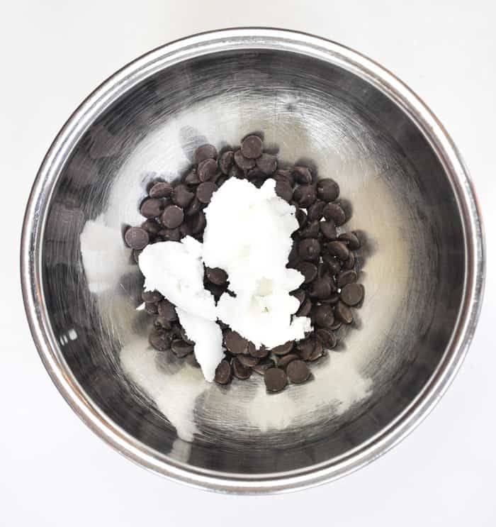 Dark chocolate chips and coconut oil in mixing bowl 