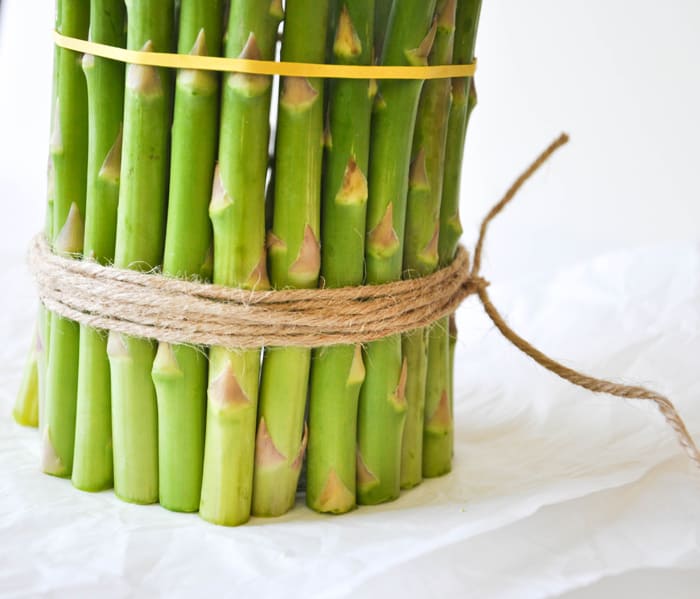 Cover a cylinder vase with fresh asparagus and fill with spring flowers!