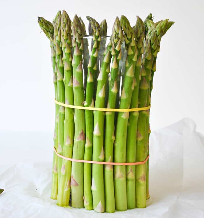 Cover a cylinder vase with fresh asparagus and fill with spring flowers!