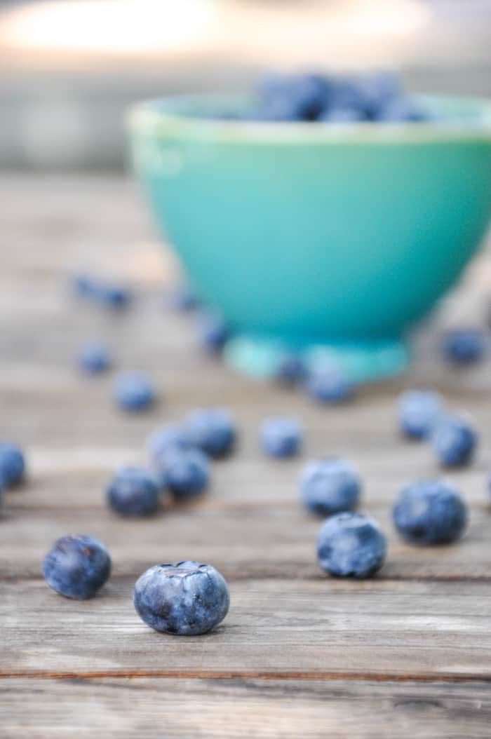 Close up on blueberry with bowl in background