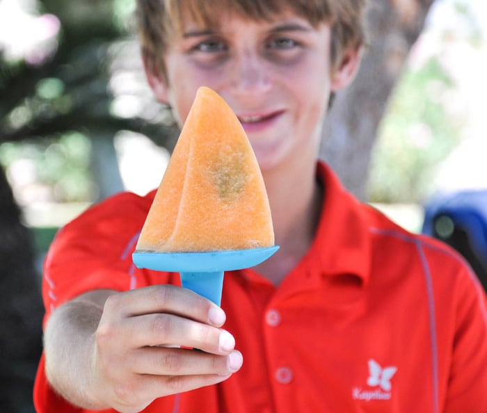 A Child Holding a Minty Cantaloupe Popsicle