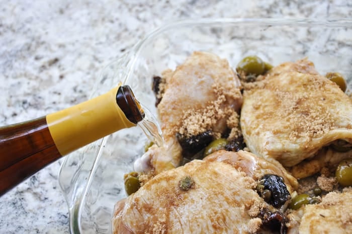 Wine being added to oven roasted chicken legs