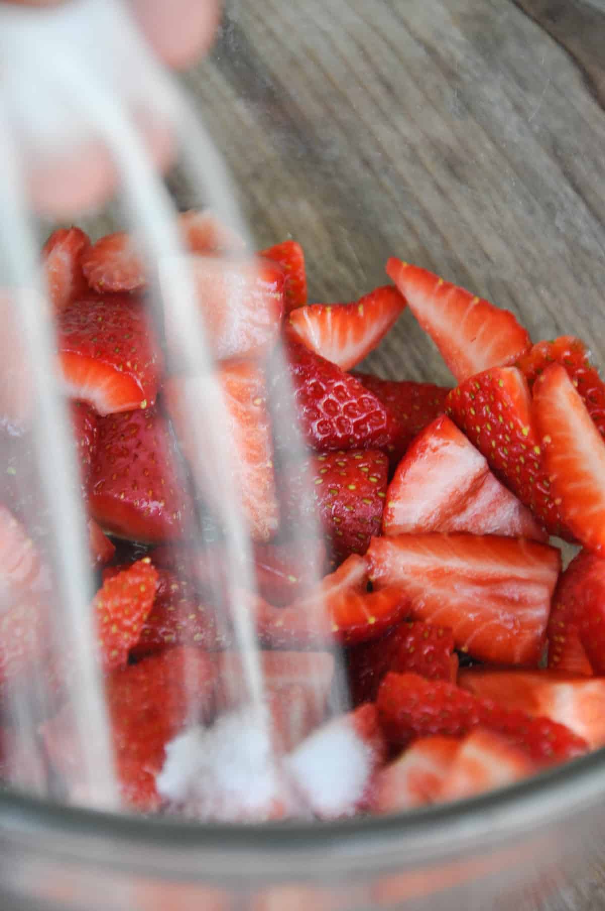 Sugar being poured over strawberries