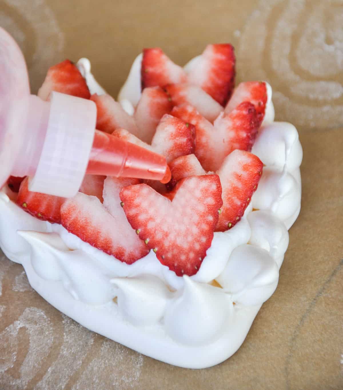 Pour strawberry juice over sliced strawberries