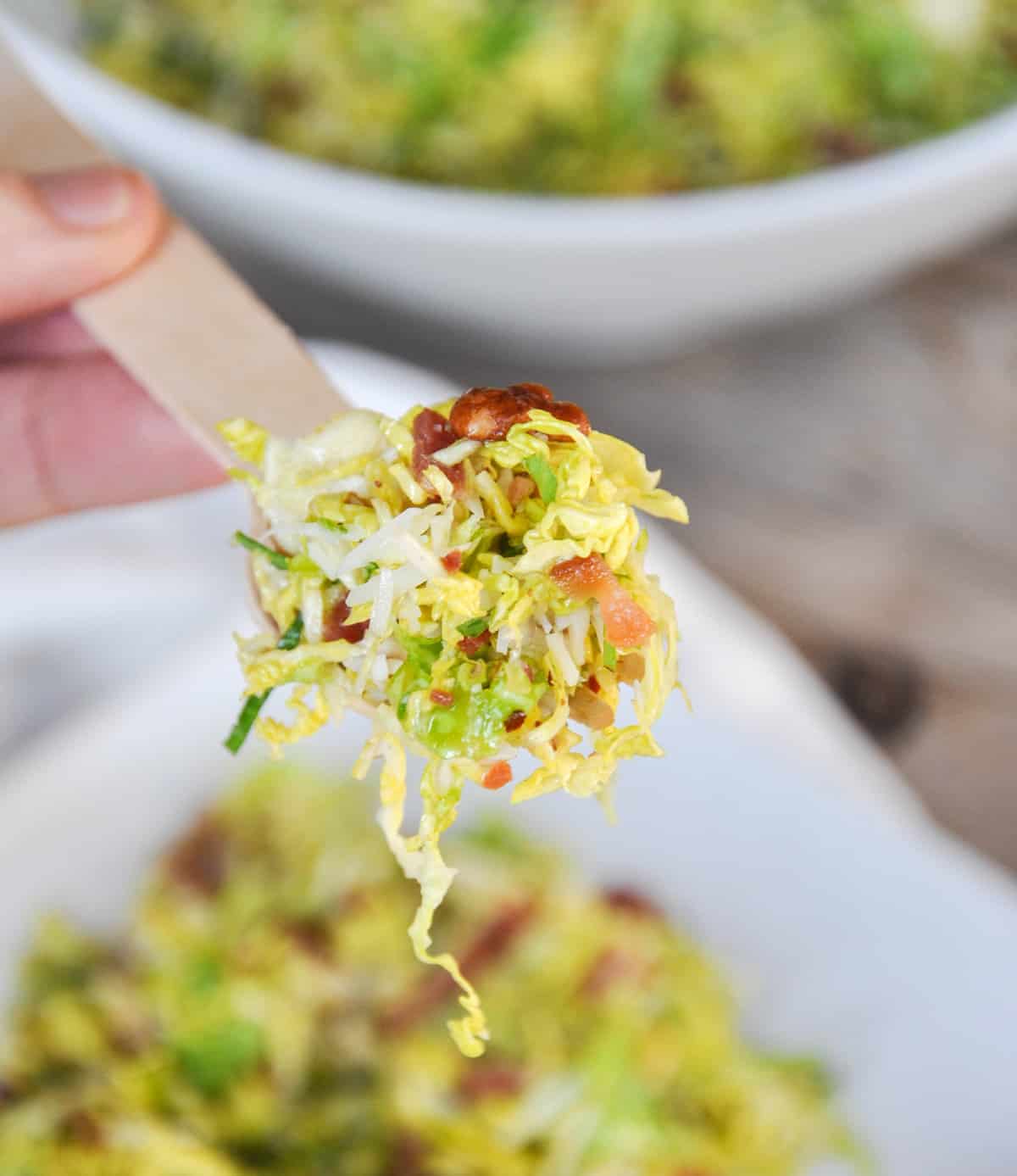 Bacon Pecan Brussel Sprout Salad with Maple Orange Dressing in a fork