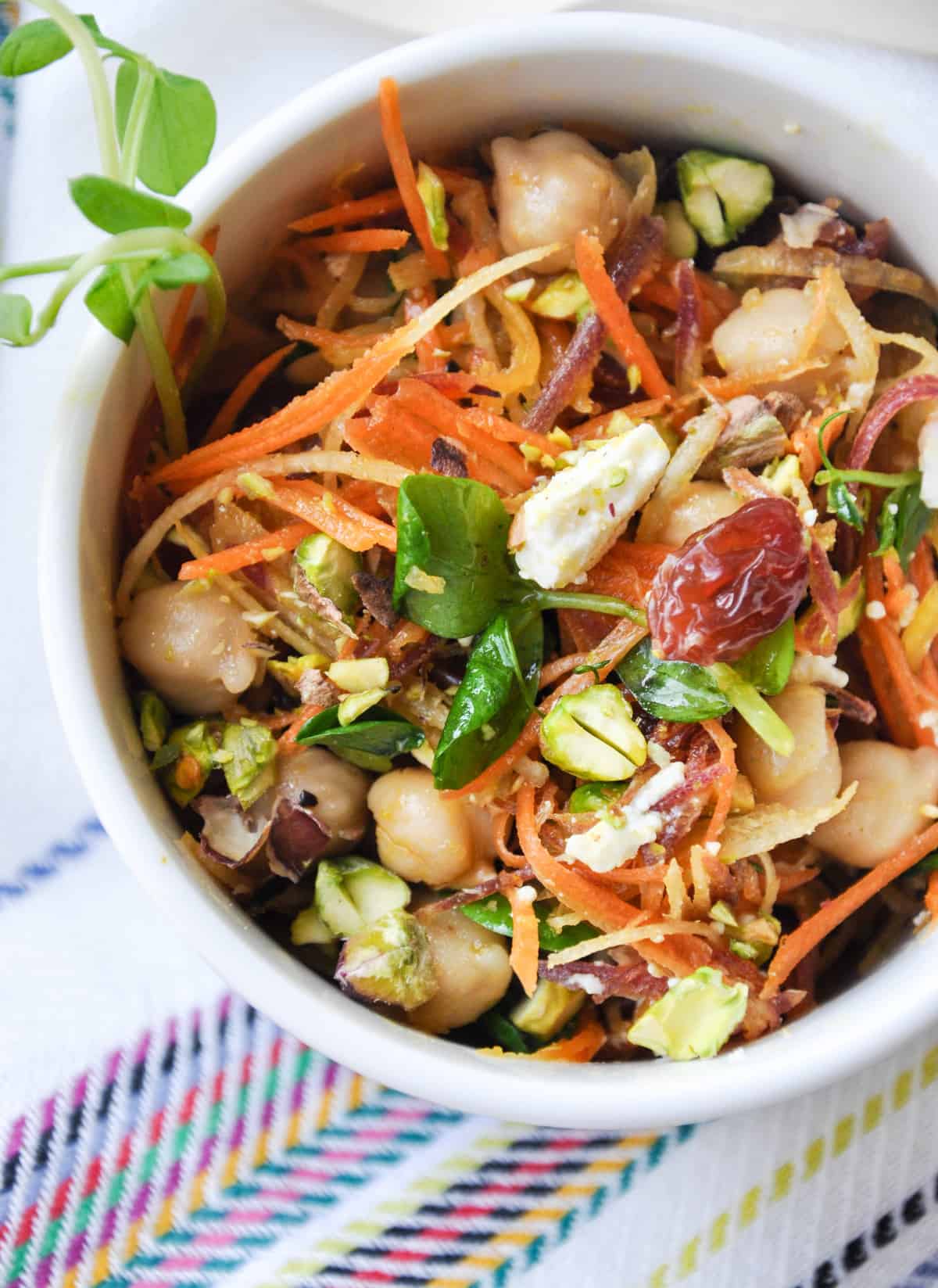 Close up of Sunshine Salad - carrot raisin salad with feta and pistachios