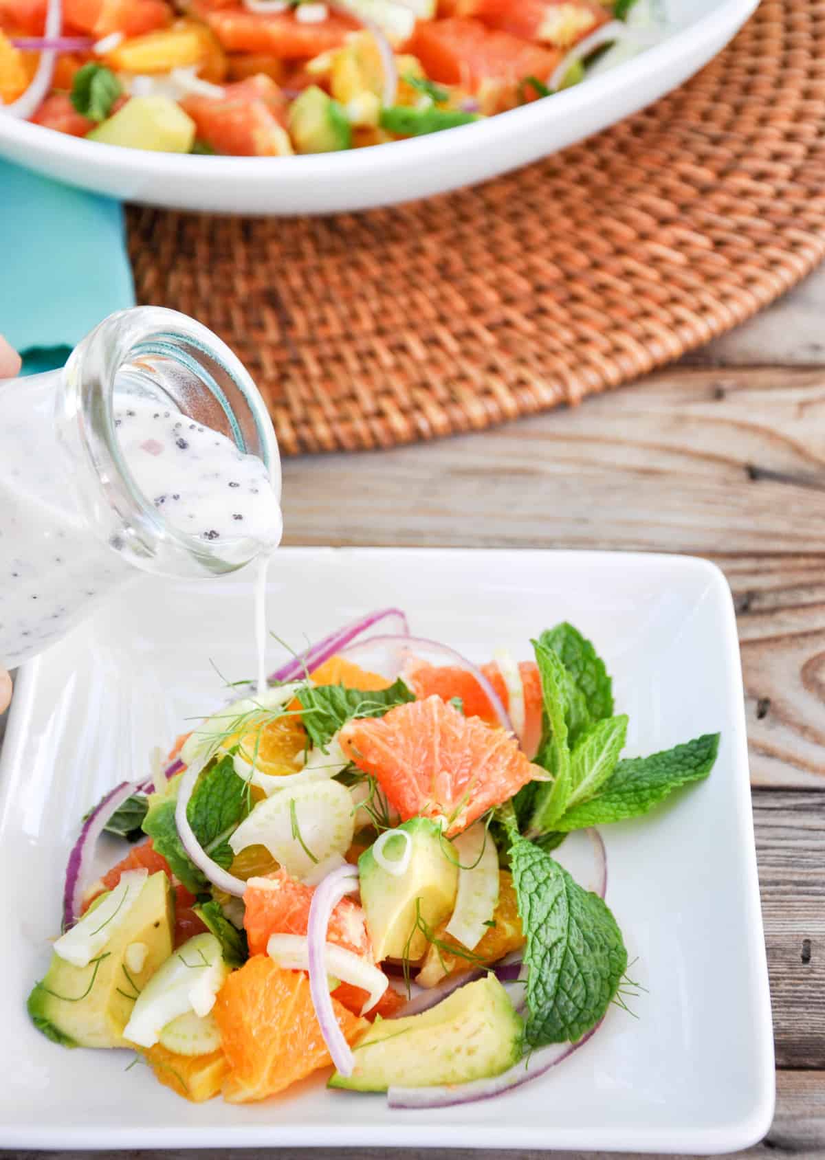 Dressing being poured over Citrus Spring Salad