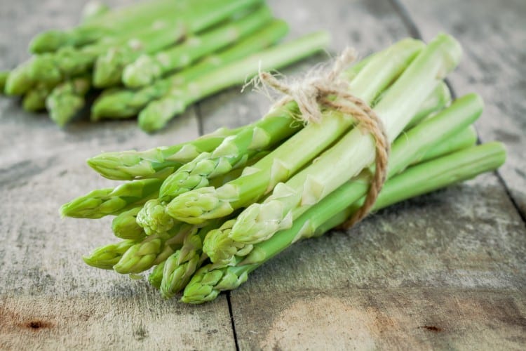 bundle of of ripe organic asparagus on a wooden background