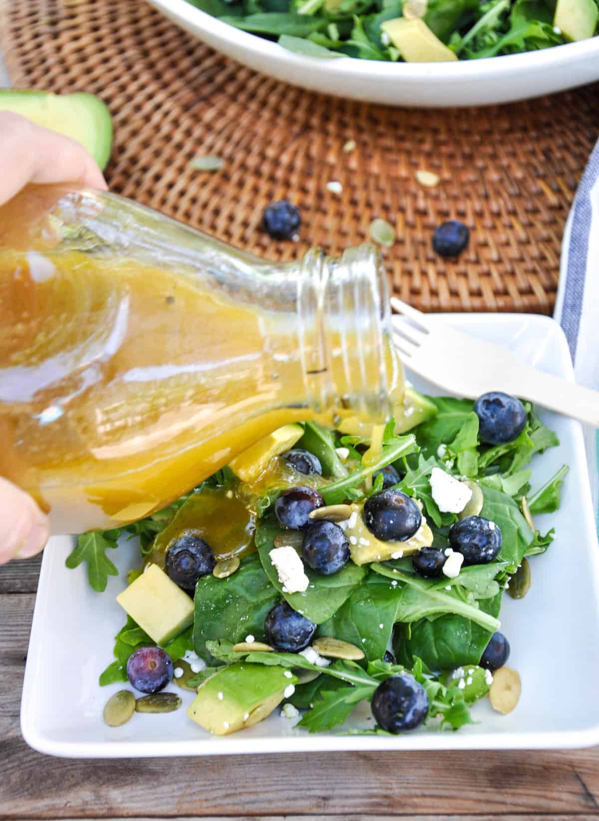 Pouring the honey vinaigrette over the salad