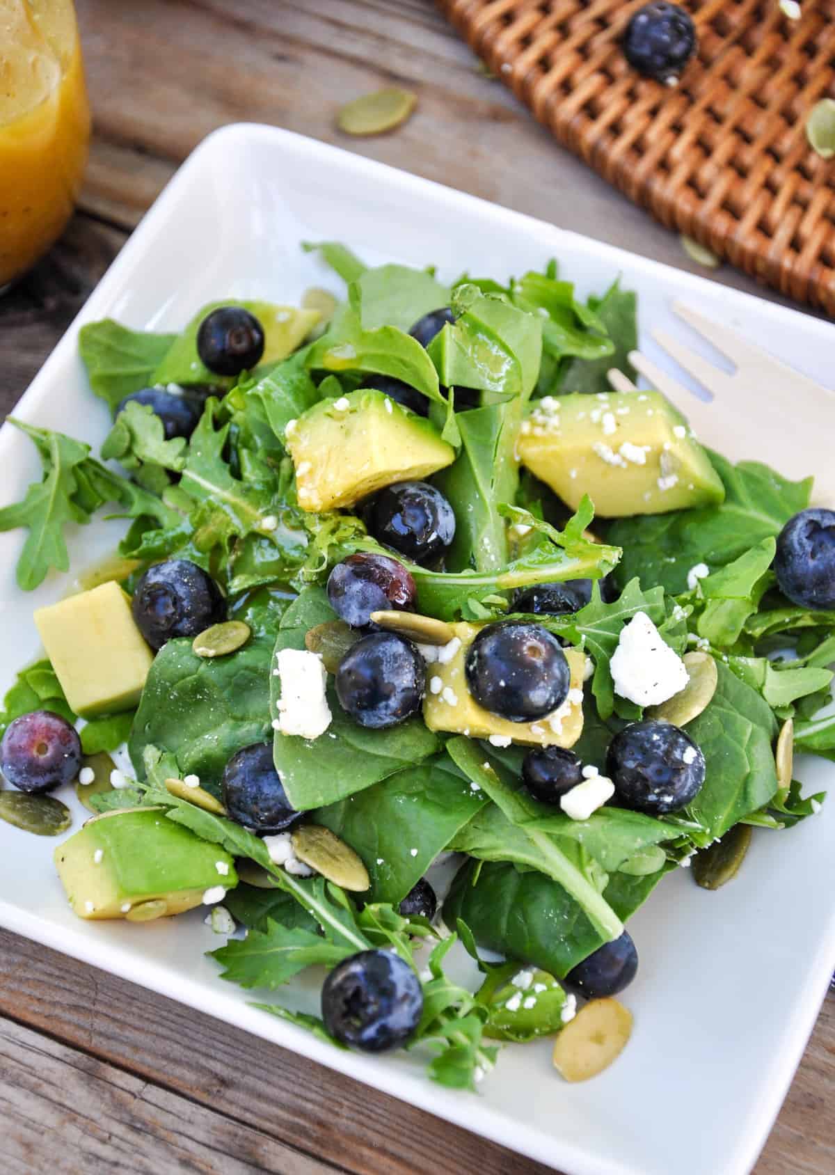 Close up of Blueberry Avocado Salad with feta, pumpkin seeds in a honey vinaigrette