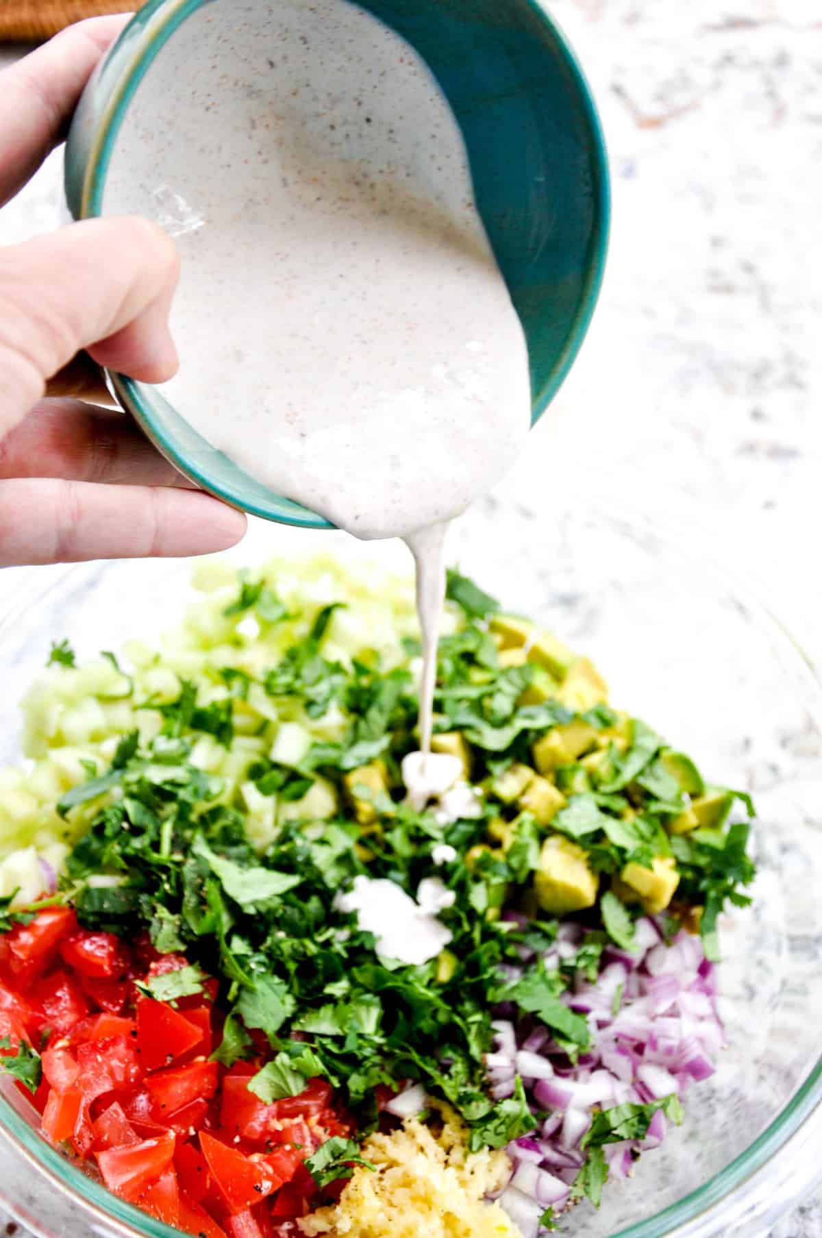 Pouring sour cream mixture over ingredients 