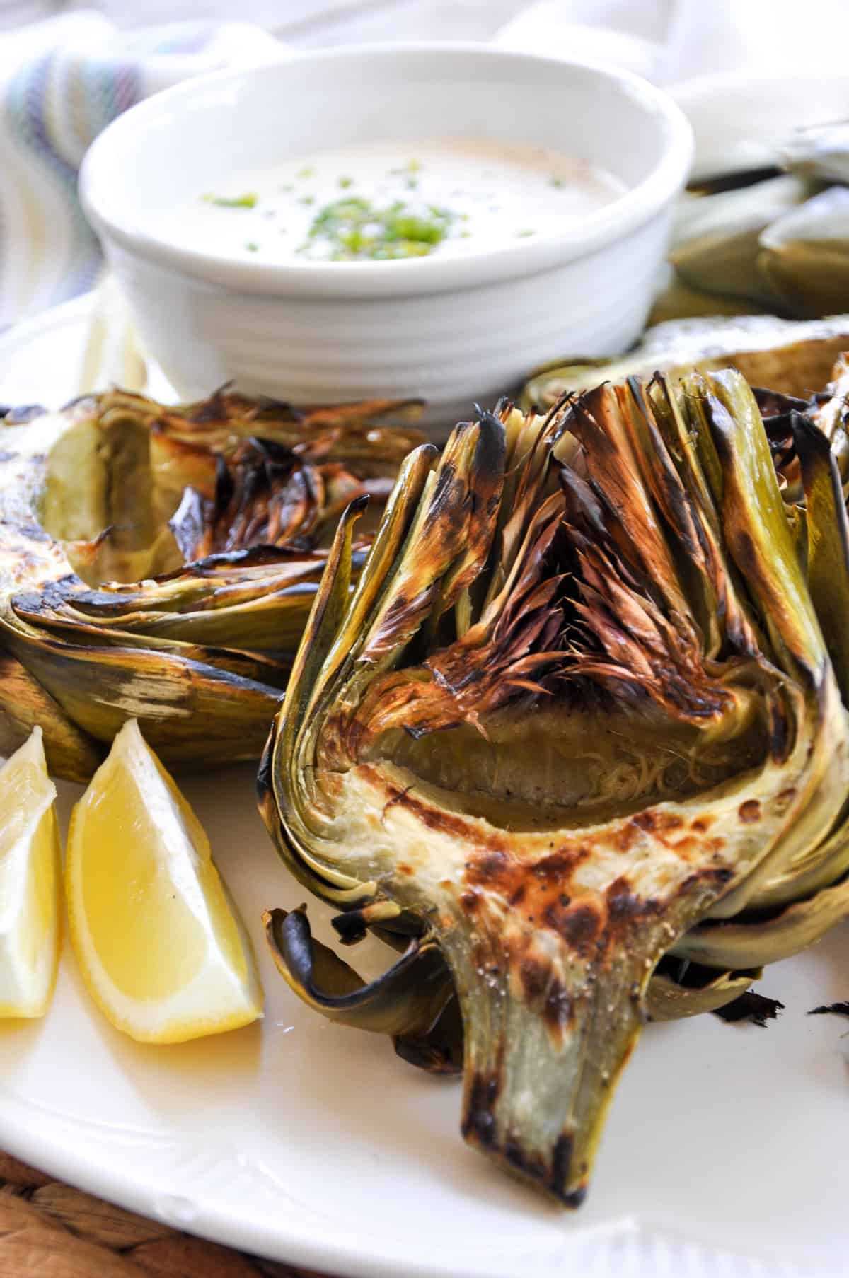 Grilled Artichokes with Zesty Garlic Aioli and a slice of lemon