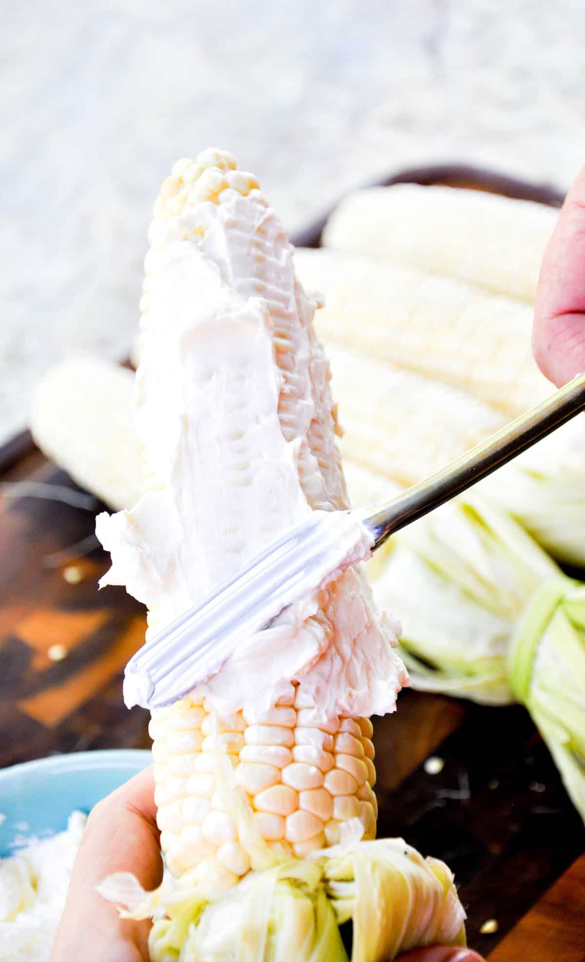 Slather the softened cream cheese onto the corn cob
