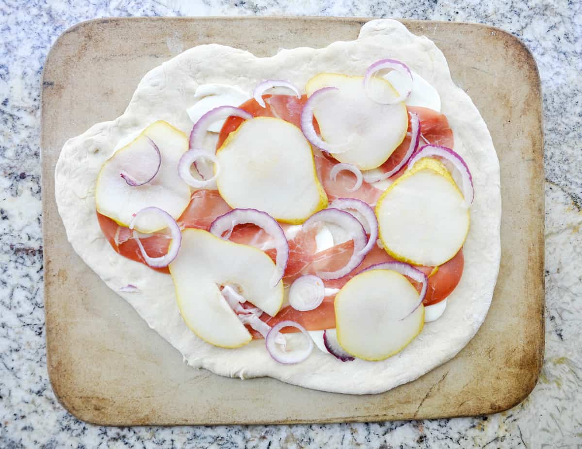 Pear & Prosciutto Pizza topped with red onion and gorgonzola. Yum-O-Licious!