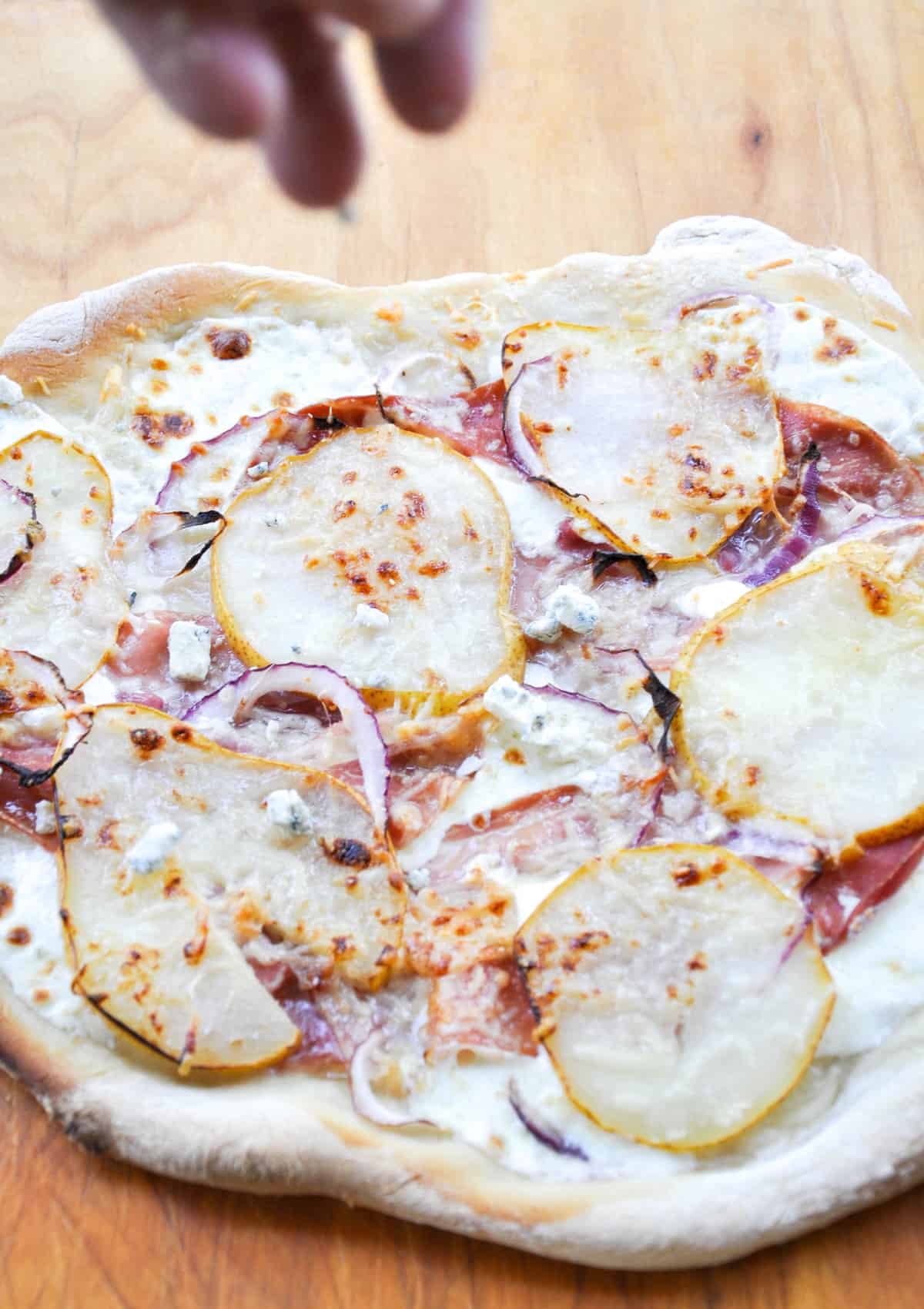 Pear & Prosciutto Pizza topped with red onion and gorgonzola. Yum-O-Licious!