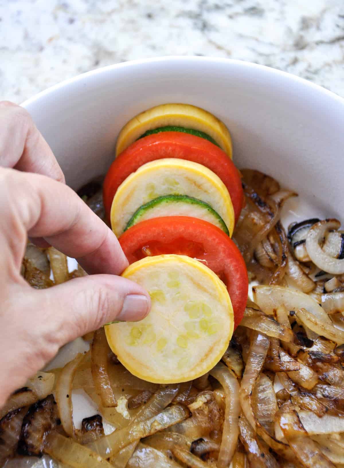 Layer zucchini and tomatoes over caramelized onion bed