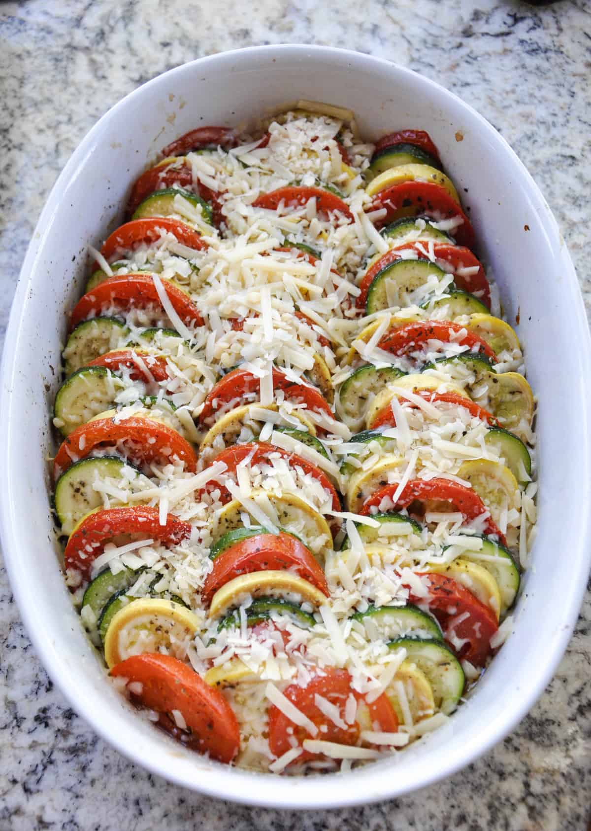 Add parmesan cheese over baked zucchini and tomatoes 