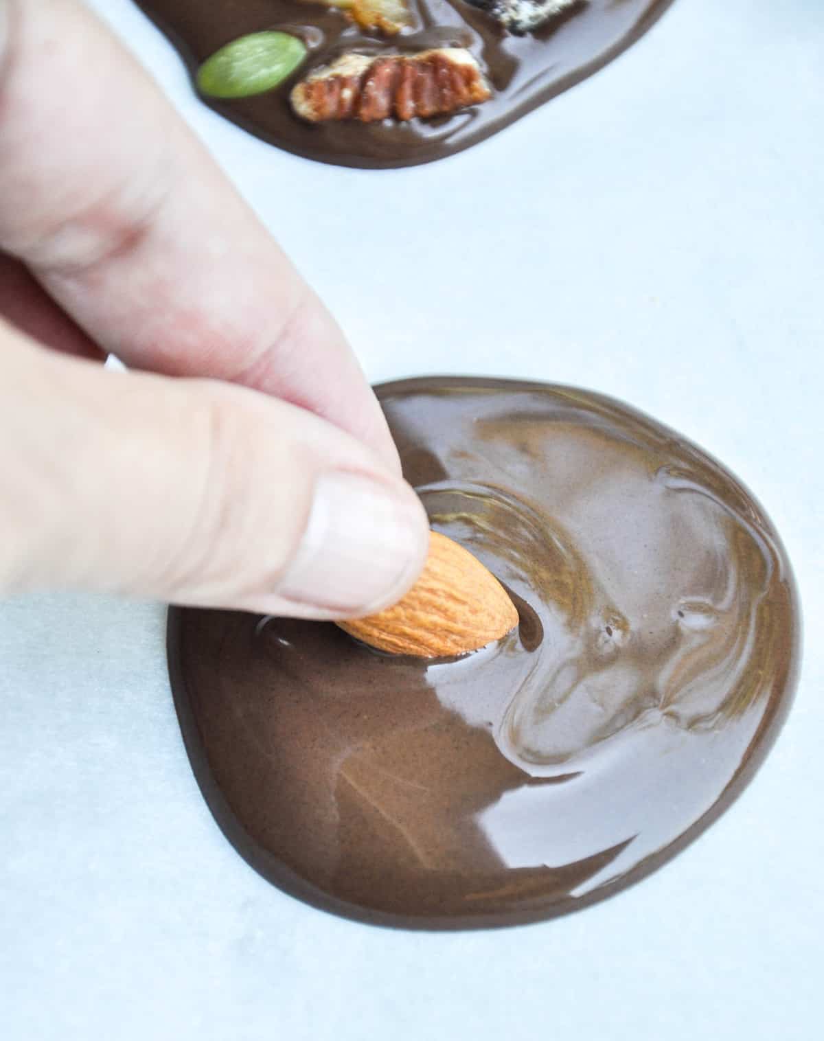 Adding dried fruit and nuts to melted chocolate rounds