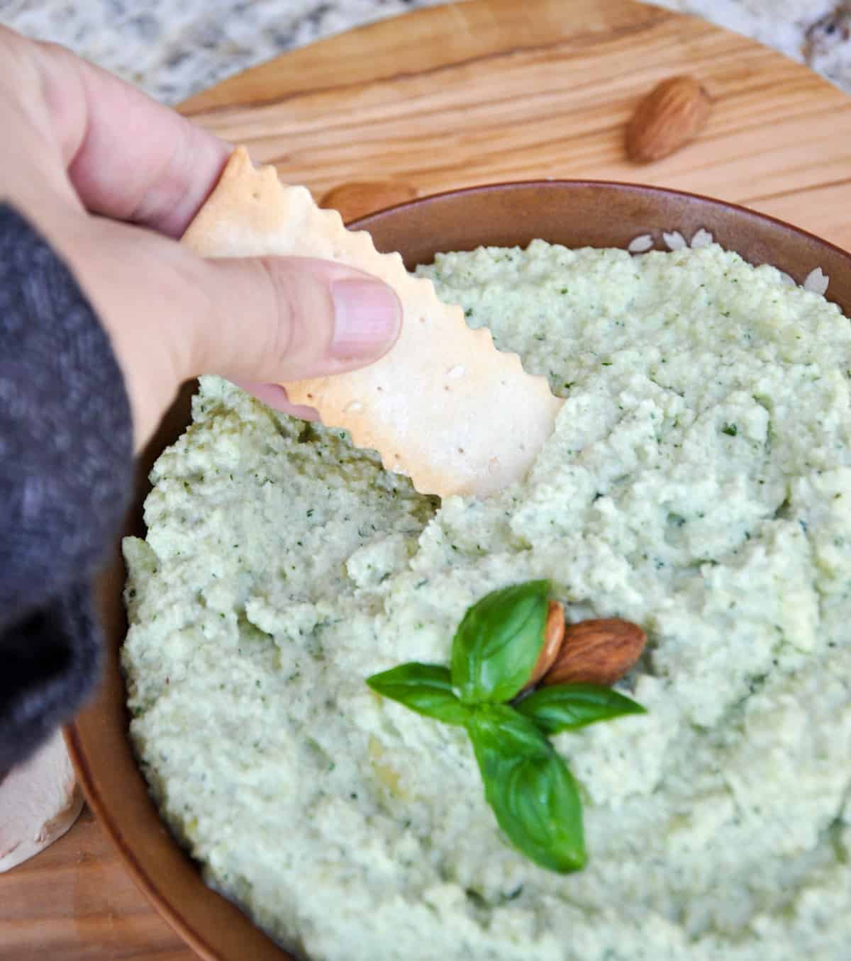 Dipping a Cracker in Basil Almond Aioli