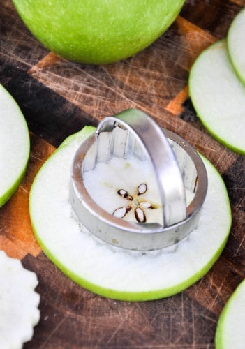 The core being removed from a Granny Smith apple slice before dipping in batter to make fried apples.