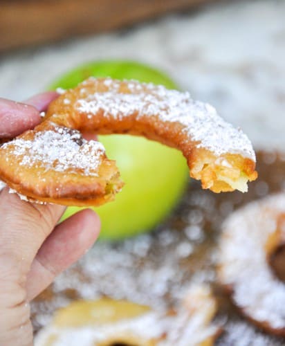 A fried apple ring with a bite taken out of it.