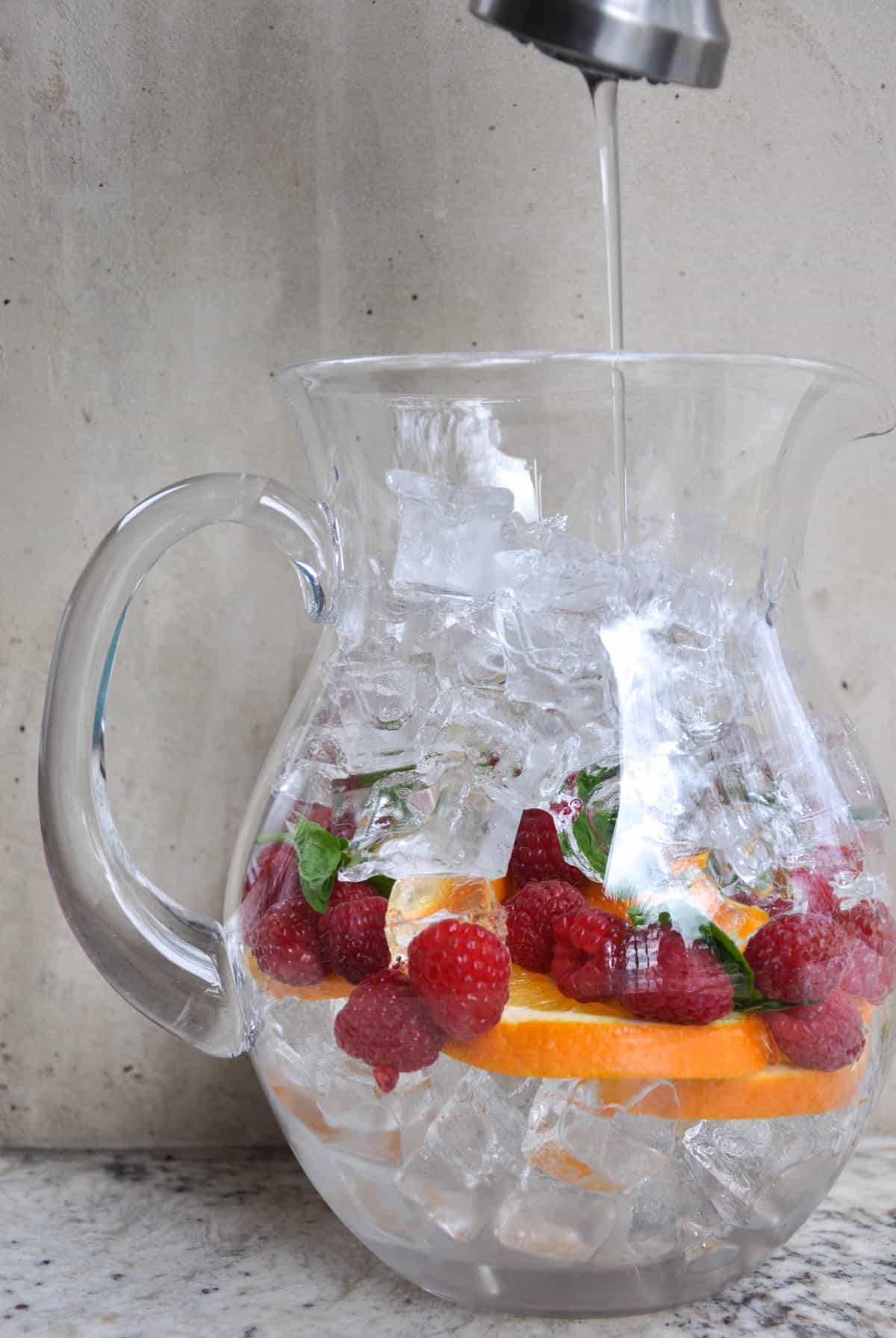 Pitcher with raspberries, mint, and orange slices