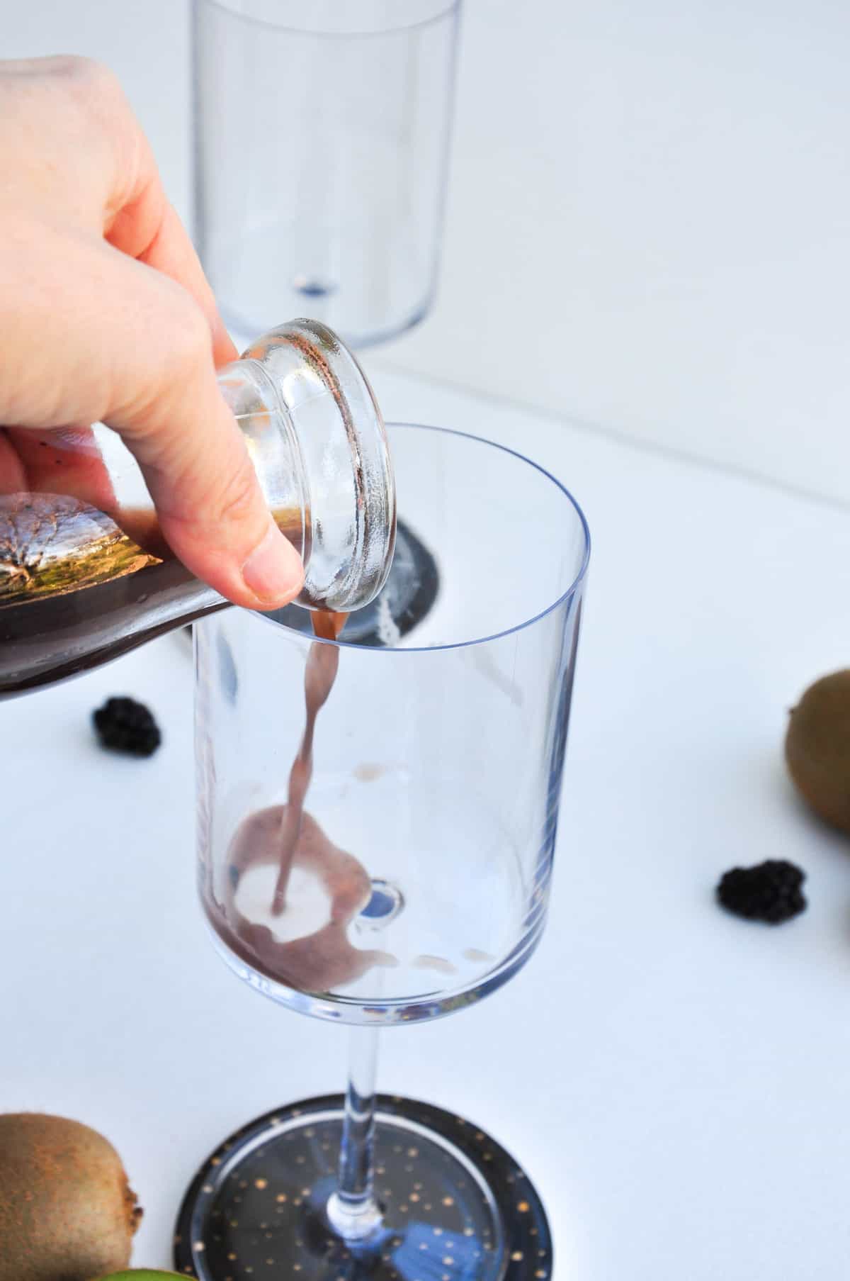 Pour kiwi juice and blackberry juice into champagne glass