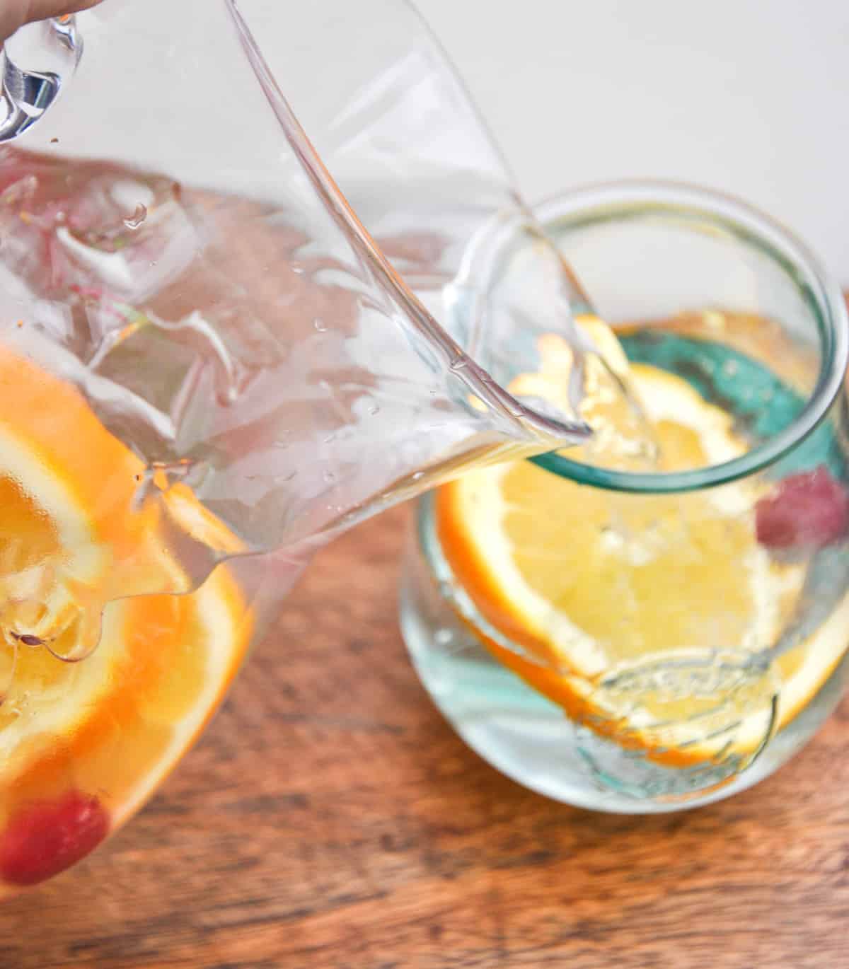Pour pitcher of detox water into glass