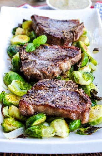 Lamb Loin Chops recipe on a platter with roasted brussels sprouts and a mustard mint sauce