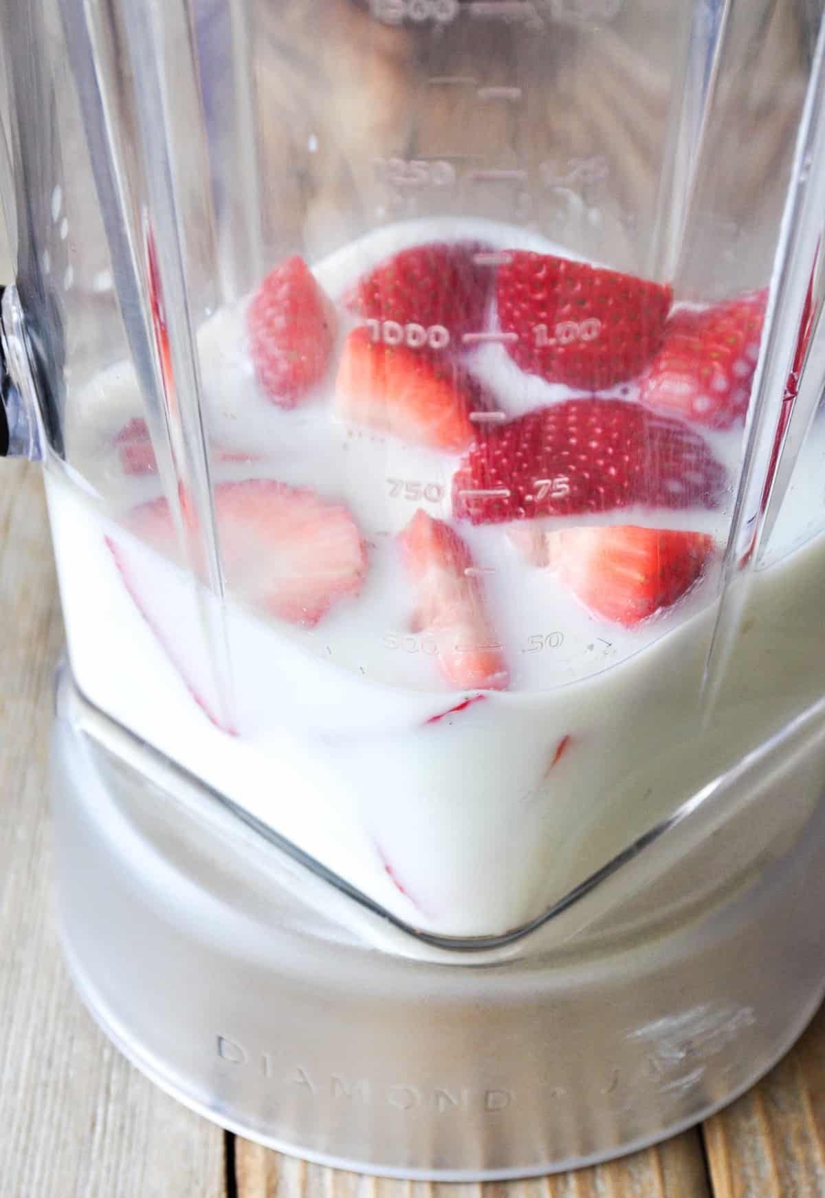 Plain Greek yogurt, milk and strawberries in blender