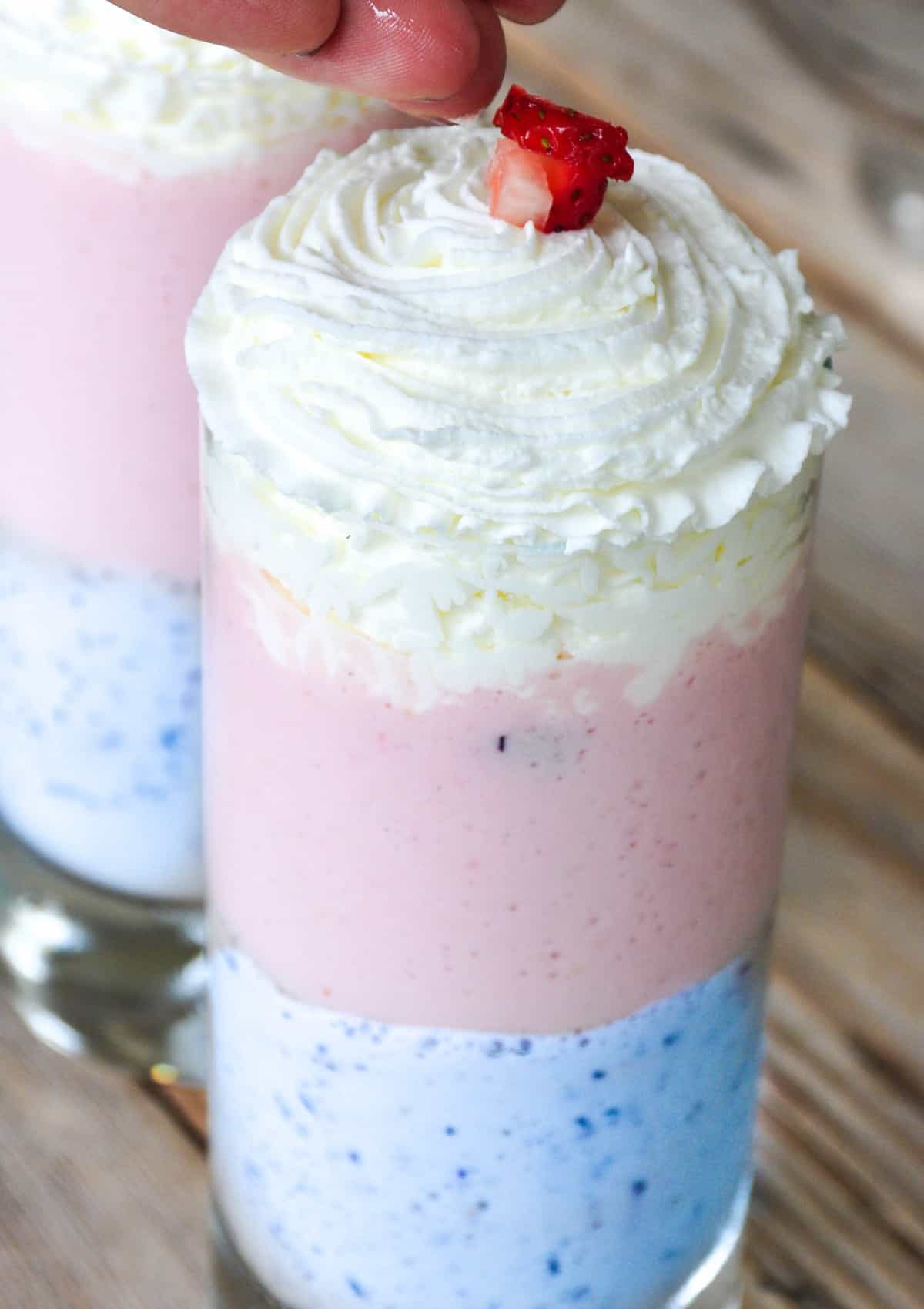 Unicorn smoothie with whipped cream and top with strawberries