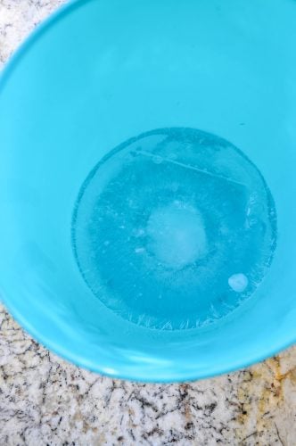 Frozen water at the base of a bucket for making an ice bucket for sparkling wine