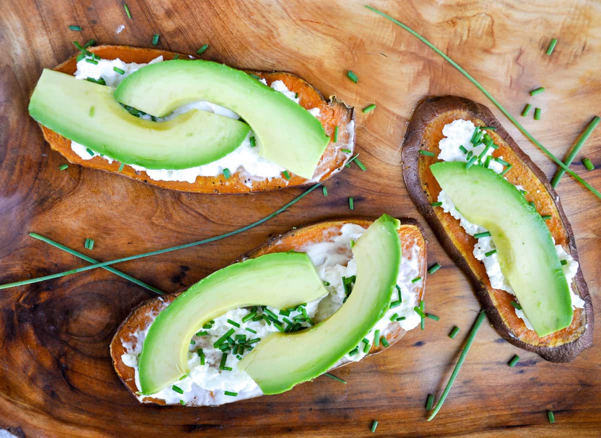 Sweetptoatoes topped with cream cheese, avocado, and chives