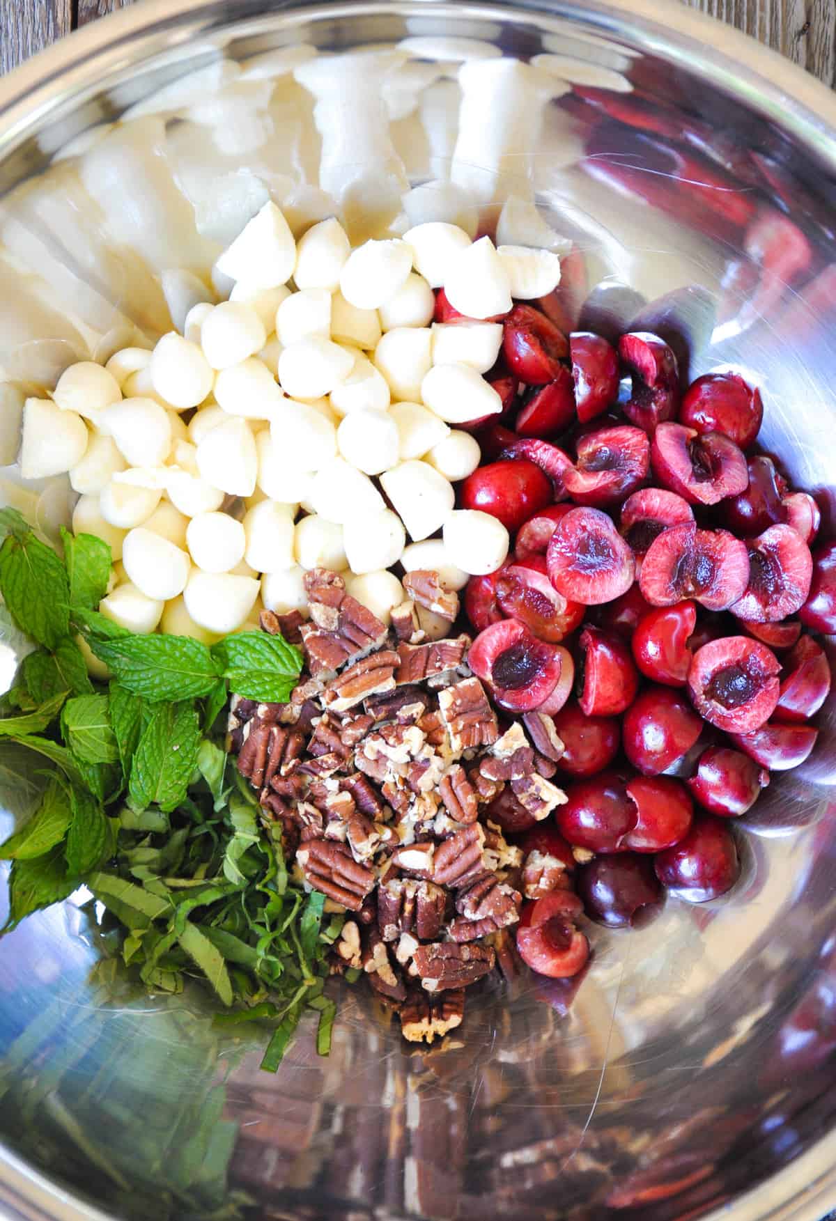 Cherry, mint, basil, pecans, mozzarella cheese in mixing bowl