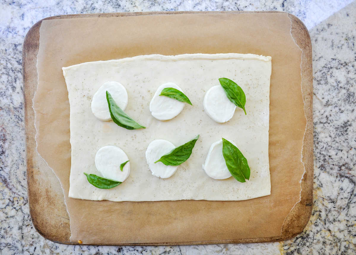 Mozzarella and basil leaves on dough