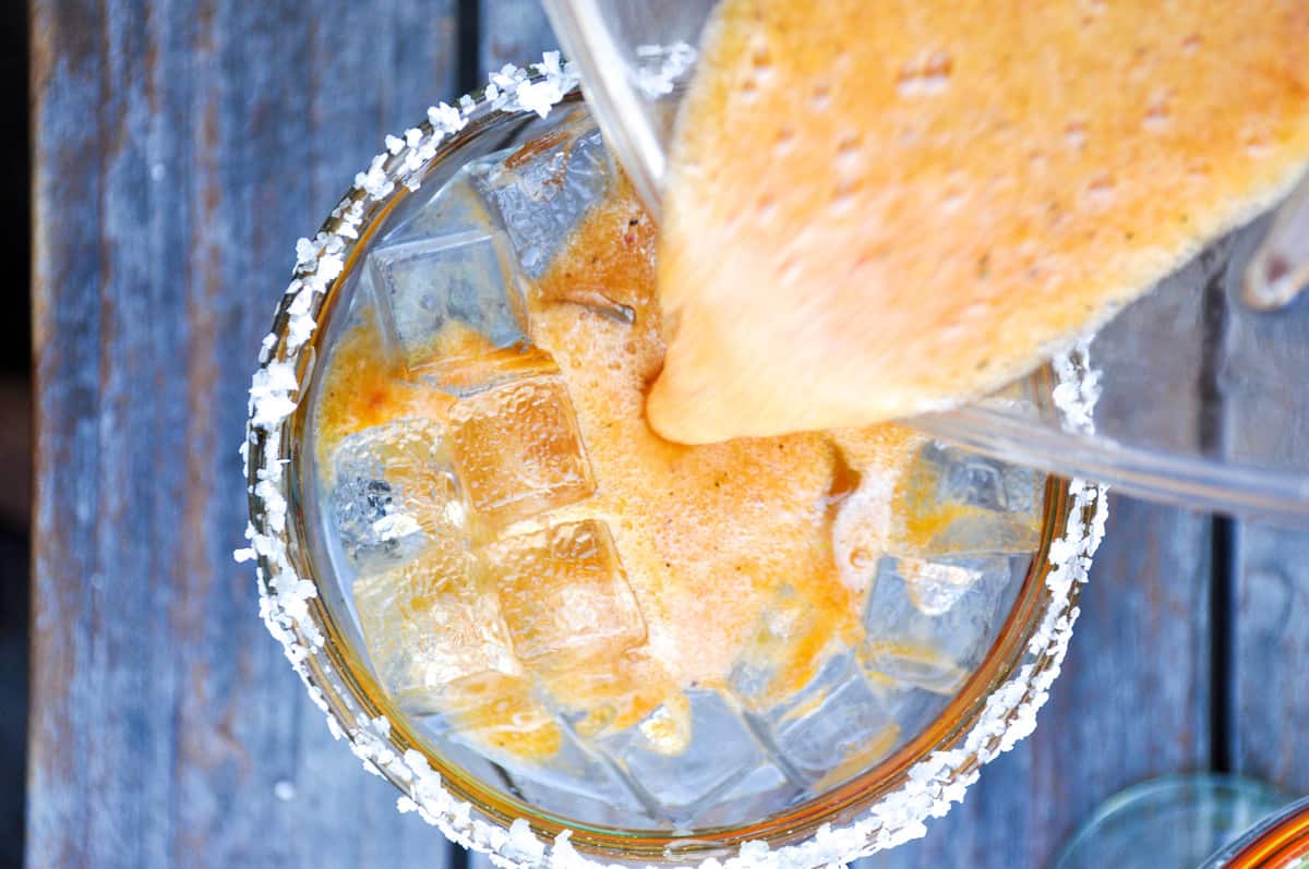 Pour blended spicy grilled peach margarita over ice 