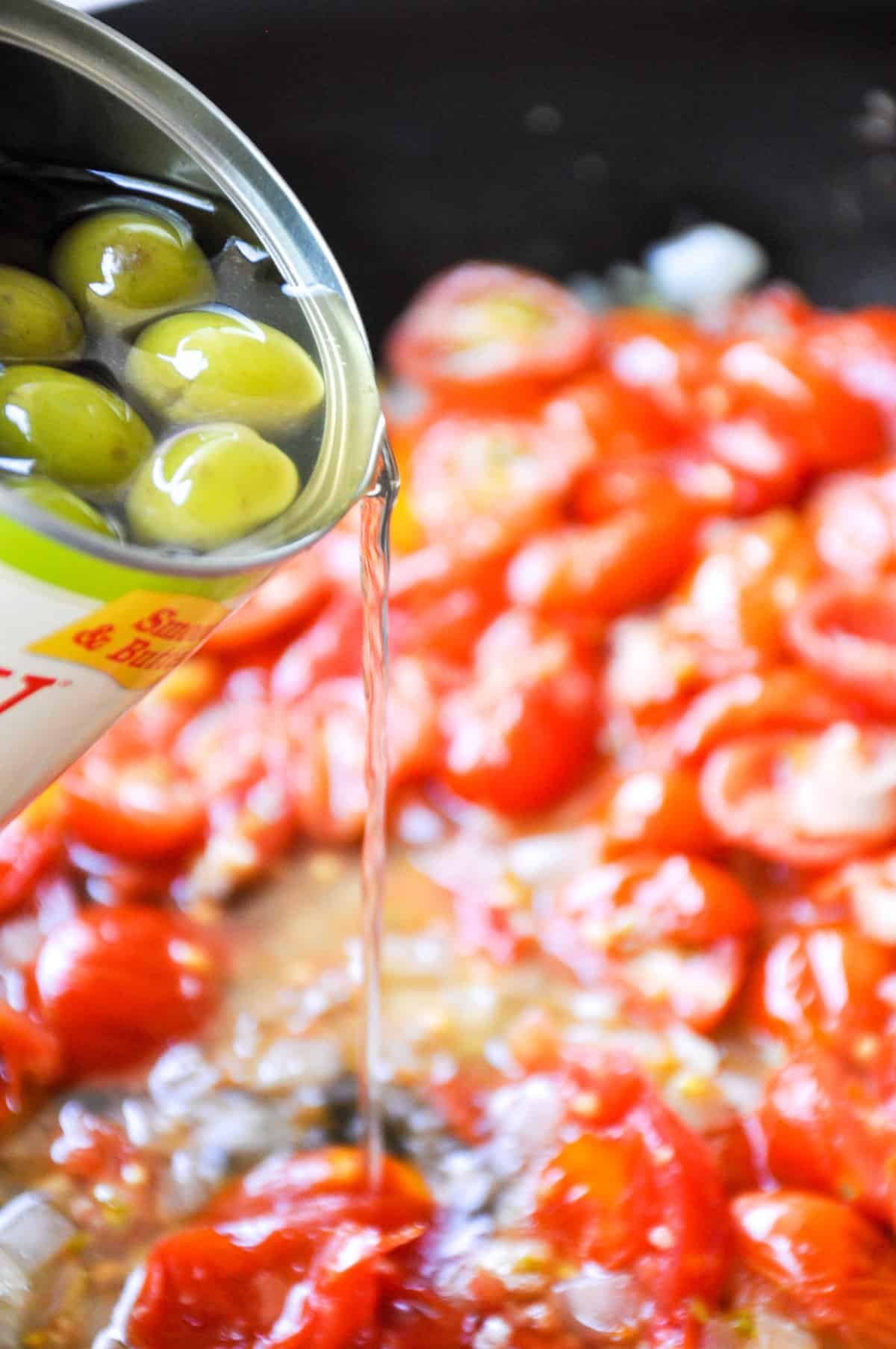 Add water from green olives can to cooked down tomatoes