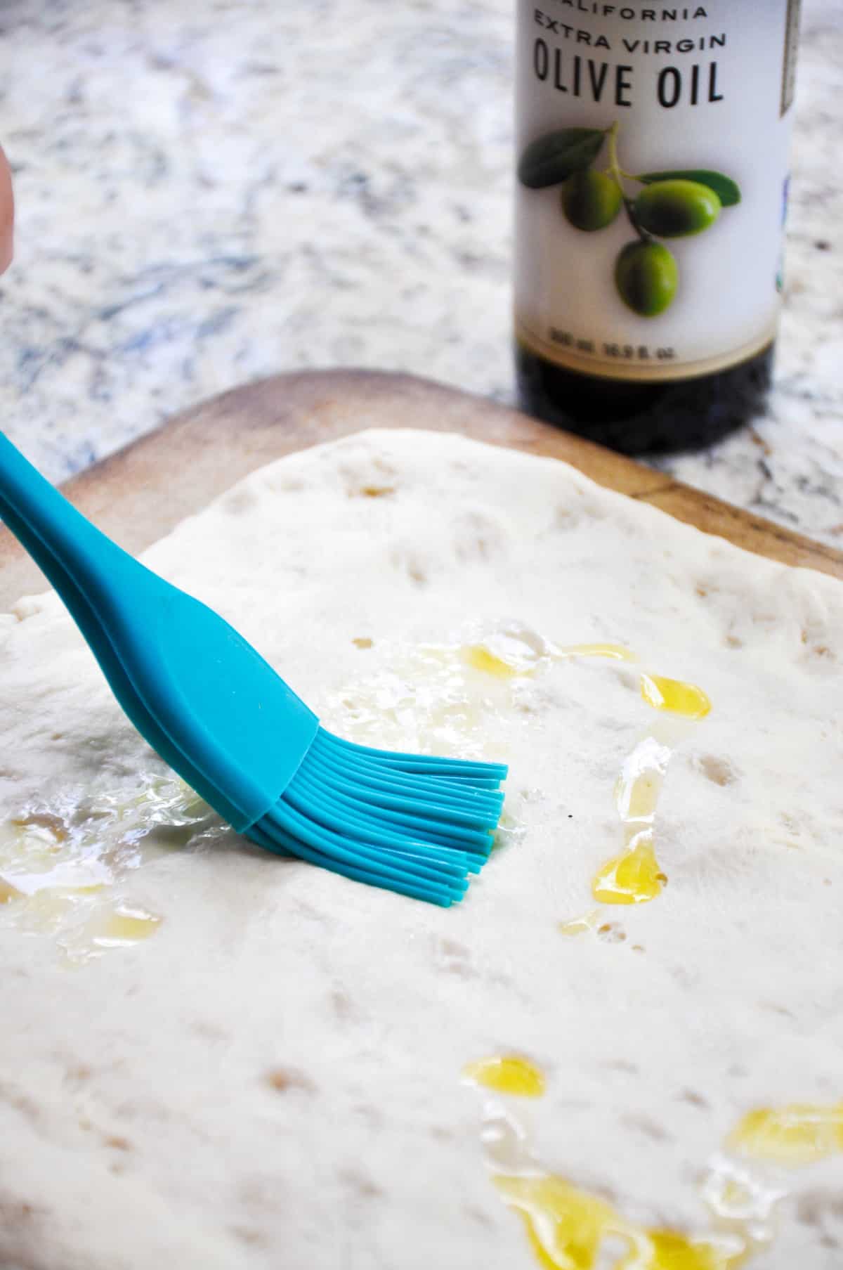 Spread extra virgin olive oil over dough