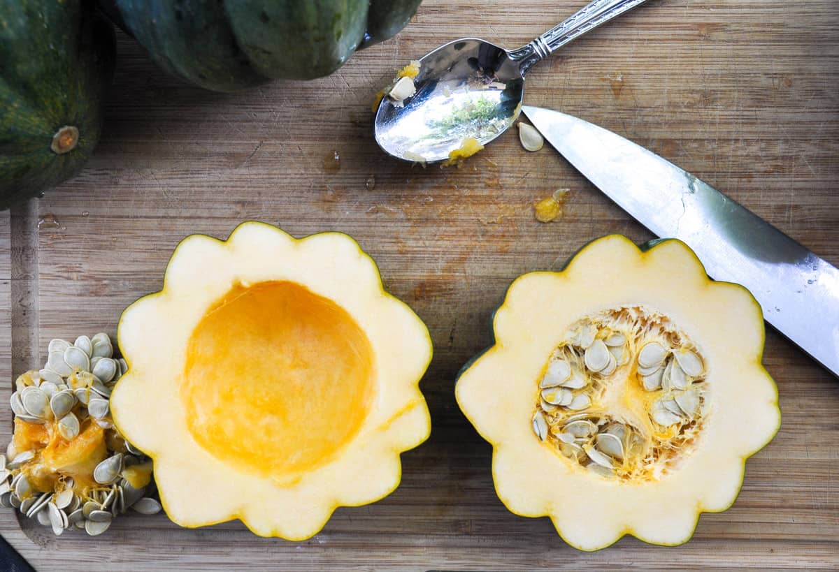 Cut acorn squash in half and scoop out seeds and pulp