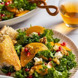 A serving bowl of Kale and Persimmon Salad.