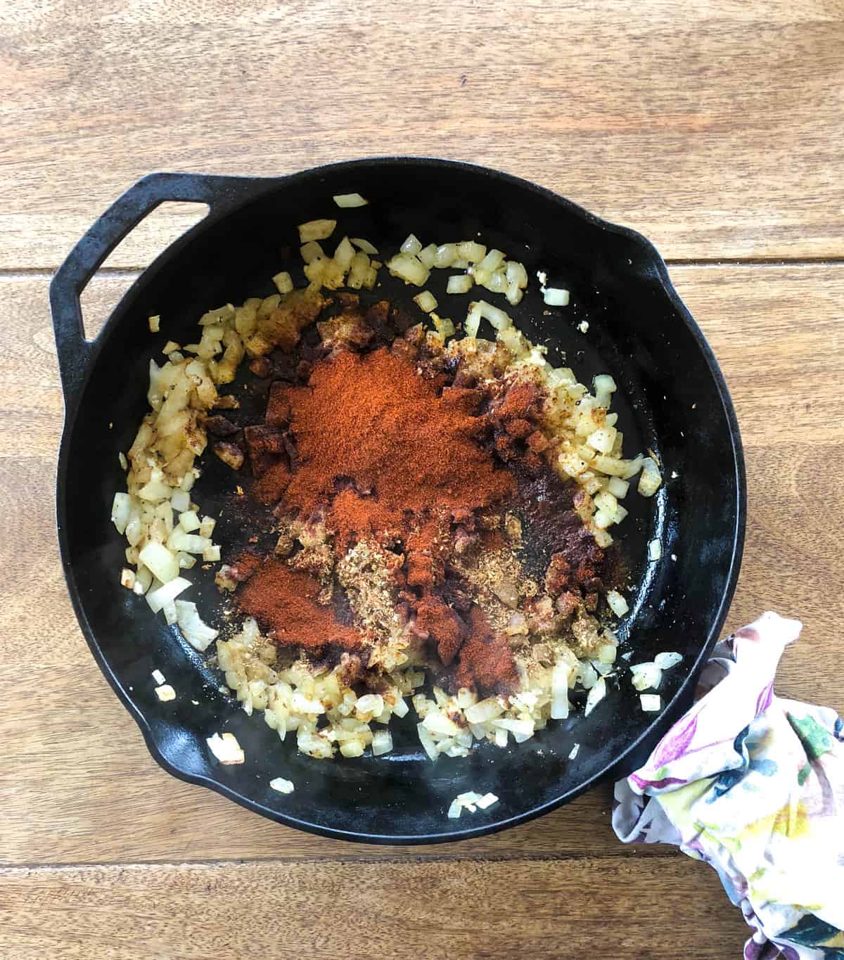 Pour two tablespoons of olive oil into a skillet and heat over medium heat. Add diced onion, garlic, and all the spices. 