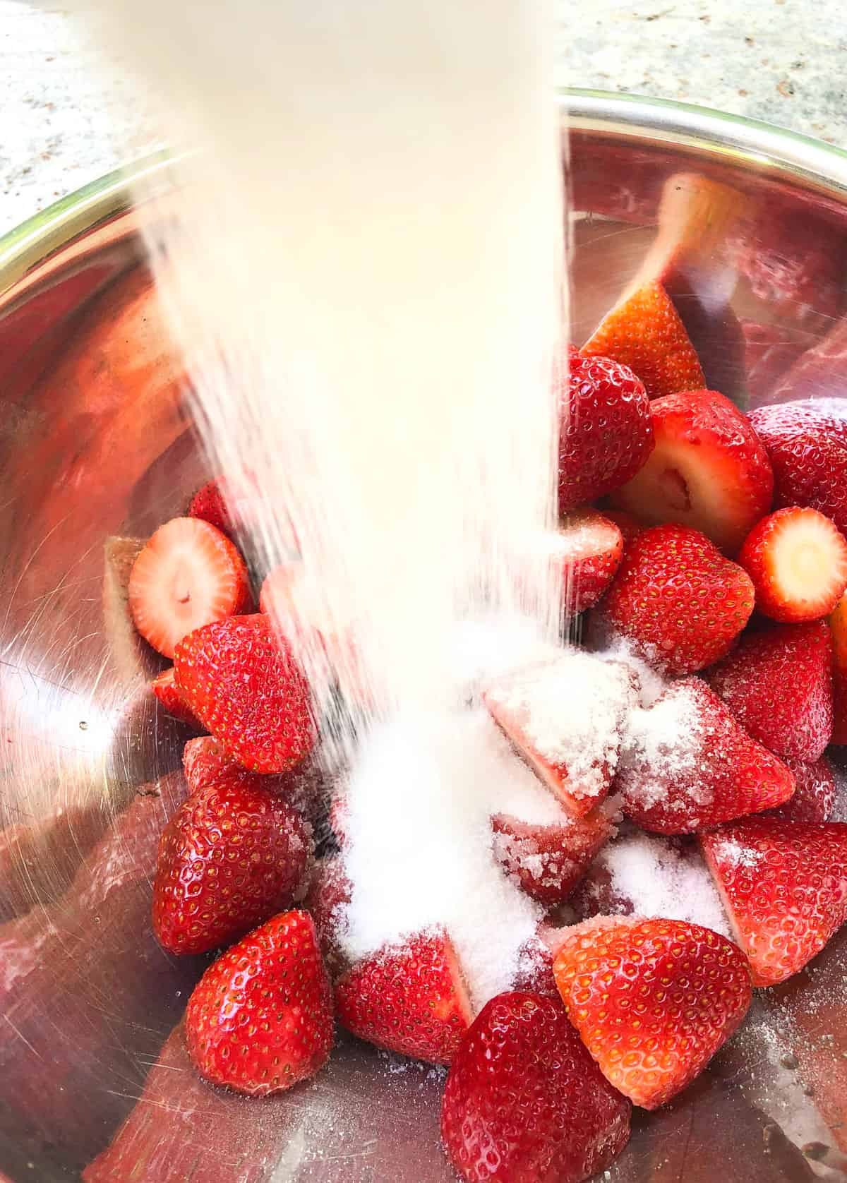 Pour the sugar over the top of the strawberries and stir to mix.